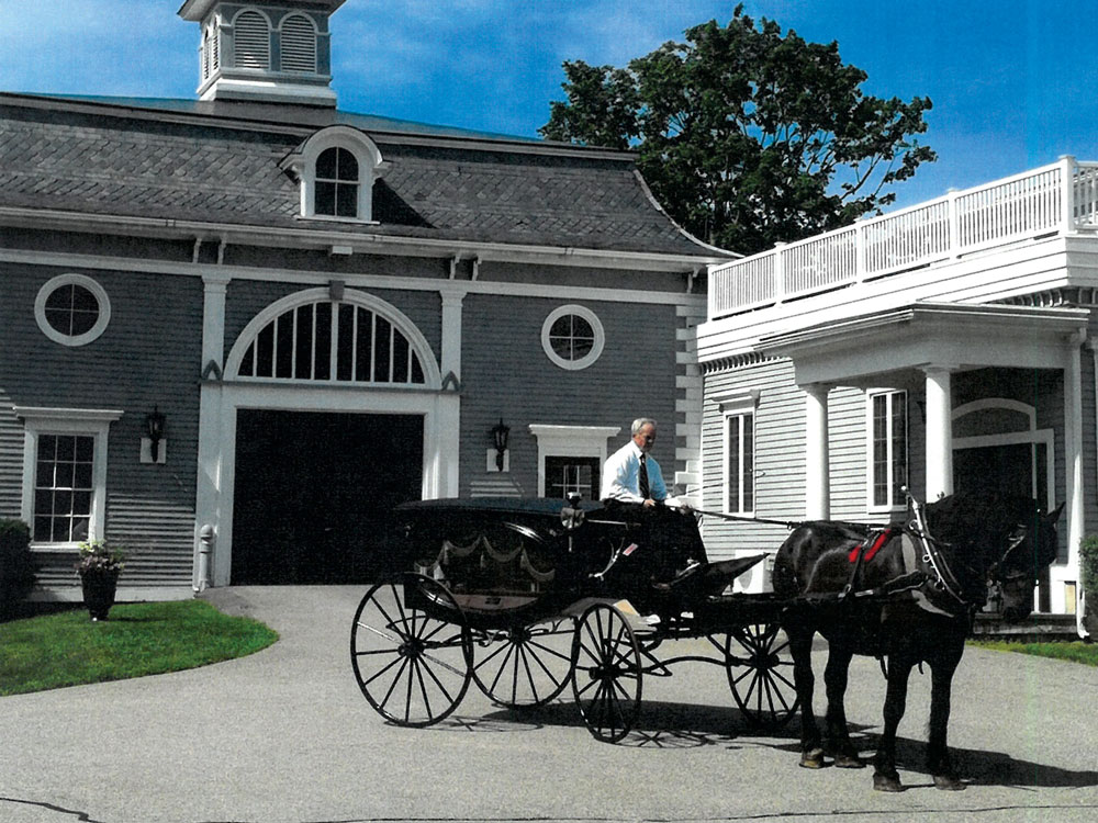 Horse drawn funeral coach with silver trimmed beveled glass lanterns constructed by Tolman, Russell & Co., Exchange Street, Worcester, Mass. in front of Bibber carriage house